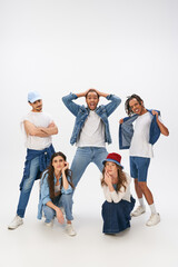 Fototapeta premium Young stylish friends showcase their trendy outfits in a bright studio setting