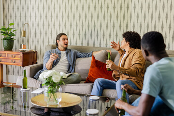 Friends enjoying drinks and lively conversation in cozy living room setting