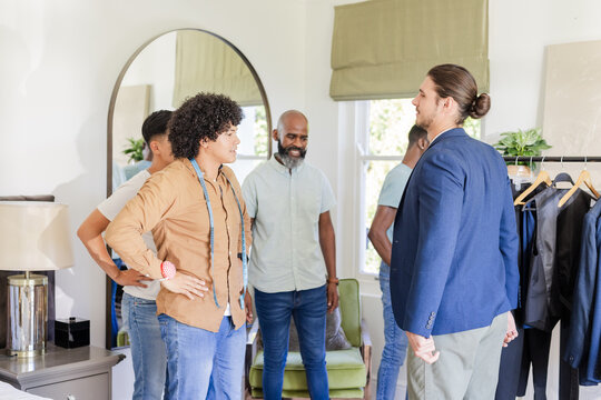 Groom and friends preparing for wedding, discussing outfits in stylish room