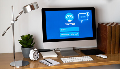 Modern office desk displaying chatbot conversation on computer screen, showcasing ai-powered customer support and automated assistance in business environment