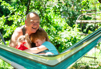 Happy children, a little boy and girl, hugging father in summer nature, love and support in the family