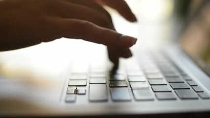 Close-up shot of a hand typing on a laptop, work at home, technology - Powered by Adobe