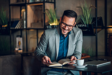 Businessman smiling and reading notes in a cafe