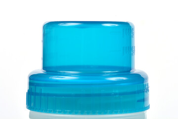 A horizontal, close-up studio shot of the top of a frosted laundry detergent bottle with a...