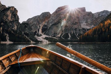 Serene boat view with majestic mountains and sunburst.