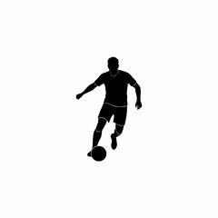 The silhouette of a soccer player dribbling the ball