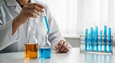 Fototapeta premium A scientist carefully adding a blue liquid to a flask in a laboratory setting