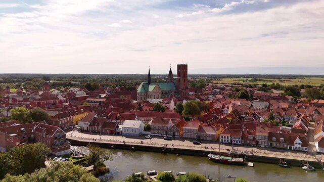 Aerial view of Ribe, Denmark, showcasing the historic Ribe Cathedral and quaint red-roofed buildings along the Ribe River, Ribe, Denmark.