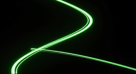 Abstract light painting with green light trails on a black background.