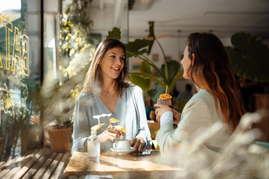 Woman talking with friend in cafe