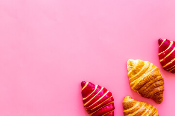 Set of croissants on pink table top view