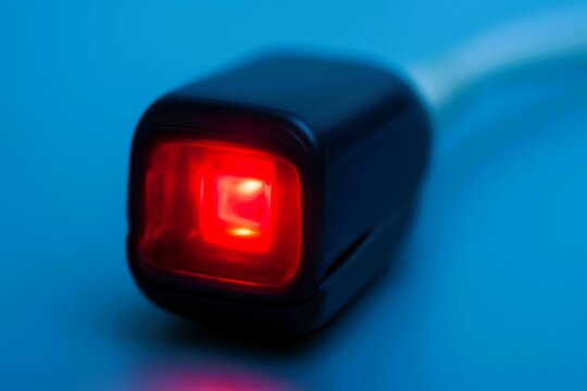Macro shot of a medical pulse oximeter glowing red, symbolizing monitoring of oxygen levels and vital signs in clinical healthcare settings. - Powered by Adobe