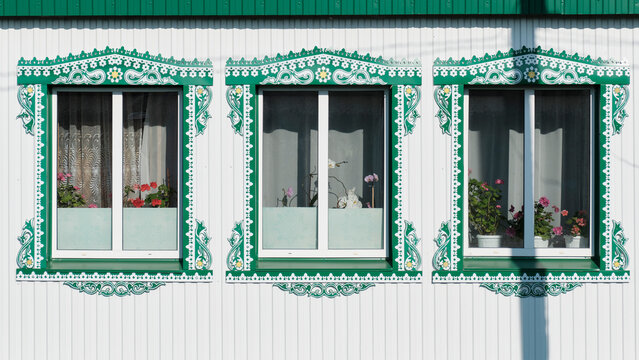 Traditional patterned metal window frames with floral decorations on house facade