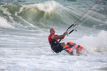Naklejka premium extreme kitesurfer riding a kite on the waves in the sea
