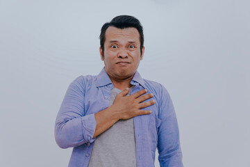 Asian man have chest pain caused by heart disease, leak, dilatation, enlarged coronary heart, press on the chest with a painful expression.