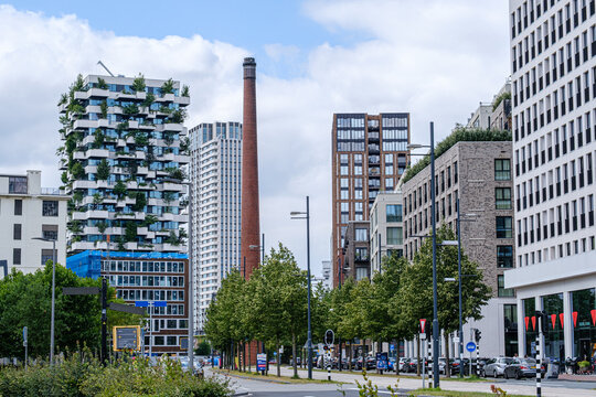 Eindhoven, Netherlands - June 28, 2025: Strijp S district in Eindhoven features modern architecture, green buildings, and a historic chimney, creating a vibrant urban atmosphere