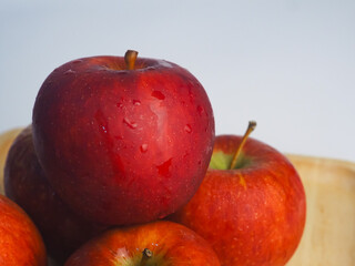 Fresh red apples on a wooden tray, close-up