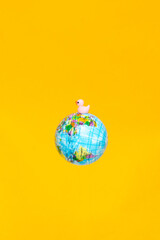 Colorful globe with a playful rubber duck against a bright yellow background creating a fun atmosphere for discovering new places