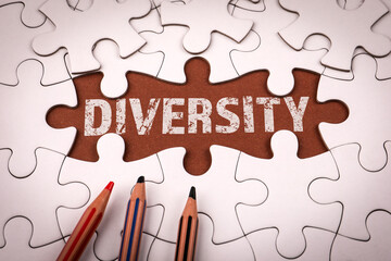 Fototapeta premium Word diversity revealed under missing puzzle piece with colored pencils. Symbolizing inclusion, equality and social unity
