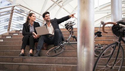 Obraz premium Commuting to work with bicycle. Businessman businesswoman cycling to office in downtown district. Modern diverse people use eco transportation on city street. Environmental pollution, climate change.