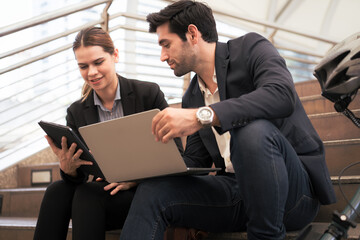 Commuting to work with bicycle. Businessman businesswoman cycling to office in downtown district. Modern diverse people use eco transportation on city street. Environmental pollution, climate change.
