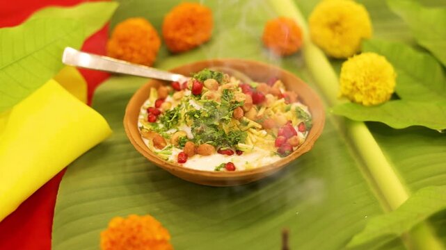 Indian Chaat Dahi Bhalle with Curd and Sweet Sauce on banana leaf with indian backdrop