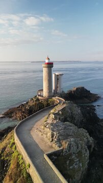 Aerial view of Minou lighthouse on a rocky outcrop, linked by a stone causeway, with the sea stretching to the horizon, Plouzan&eacute;, France.