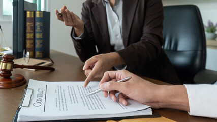 Legal Consultation. Lawyer explaining contract details to a client in an office.