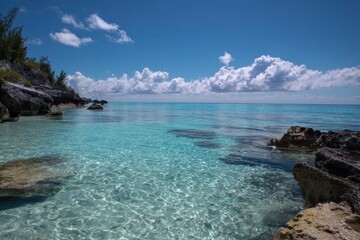 Fototapeta premium Crystal-Clear Turquoise Water Meets Rocky Shoreline on Sunny Day