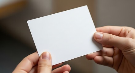 Obraz premium Hands Presenting a Clean White Card, Ideal for Mockups and Presentations