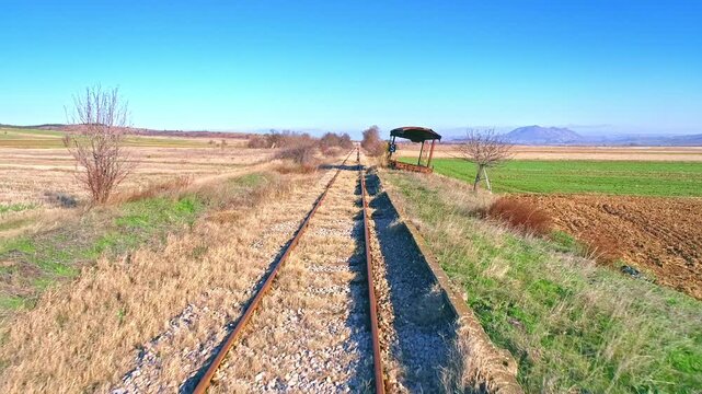Drone flight above railway track in the valley, old wrecked abandoned wagon