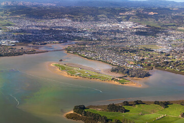 Pararekau Island and Manukau Harbour, Auckland, New Zealand, aerial view. Development in 2025 of gated exclusive subdivision on the island. Motorway, Karaka, Papakura, Takanini and Ardmore in distance