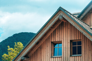 Attic window of a traditional alpine house in Slovenia, typical rural architecture with wooden facade details.