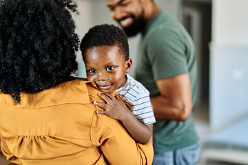 Portrait of a happy black family mother father and kid son at home on couch