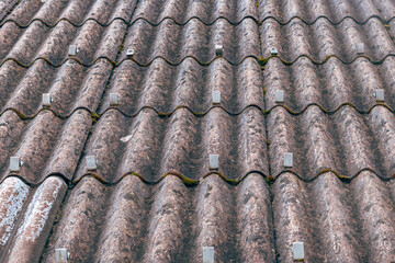 Snow guards mounted on asbestos fiber cement roof sheets, industrial building detail.
