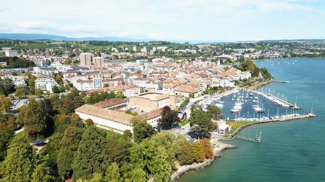 Aerial view of Morges, where terracotta rooftops meet the turquoise waters of Lake Geneva, a vibrant blend of urban and natural beauty, Morges, Vaud, Switzerland.
