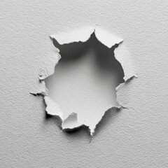 A circular hole punched through a textured white surface, creating radiating, jagged edges