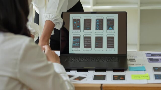 Web designers comparing mobile and laptop layouts