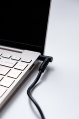 Charging laptop with power adapter isolated on white background