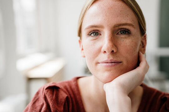 Portrait of a thoughtful woman in loft with hand resting on chin