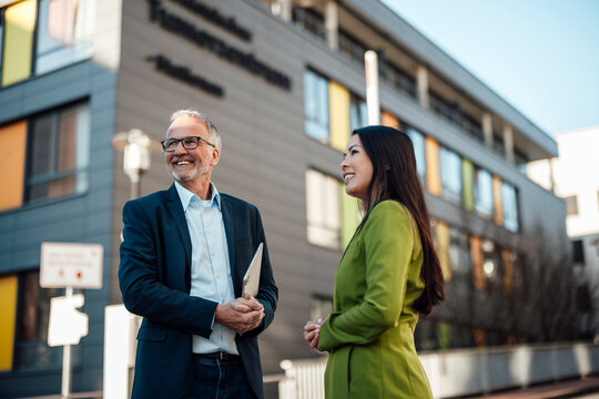 Business team collaborating outdoors at clinic building