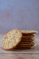 Rustic stack of cheese crackers on wood—simple, wholesome snacking with artisanal appeal. Selective focus.