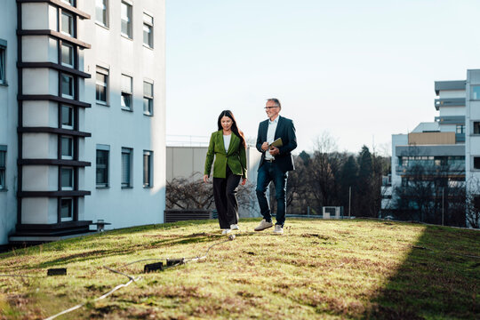 Business professionals collaborating on a green rooftop outdoors