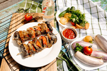 Juicy grilled liver with vegetables on picnic, sunny day, casual alfresco summer meal