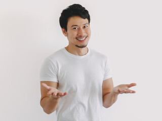 Asian man shrugging with palms up and confused expression in white shirt and clean background