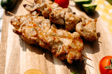 Juicy grilled fish skewer with assorted vegetables on picnic table, outdoor dining experience