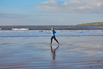 A young woman embraces the tranquility of a seaside run along Essaouira's ocean