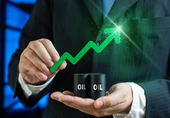 Rising oil prices. Barrels of oil and a green arrow in the hands of a businessman. Symbol of...