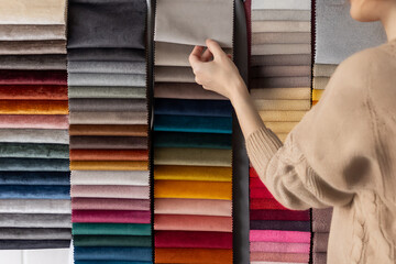 A person choosing fabrics and colors in a showroom. Ideal for interior design, consulting, home renovation, and furnishing material selection projects.