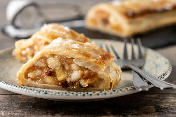 Homemade apple strudel slice on wooden table